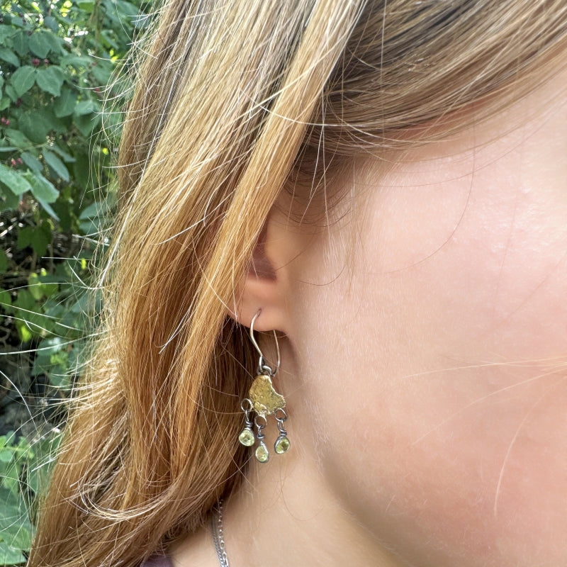 Hanging earrings with organic shape gold plates and peridots