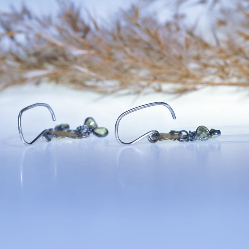 Hanging earrings with organic shape gold plates and peridots