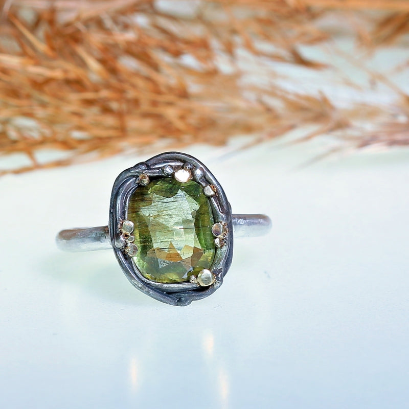 Ring with peridot with Ludwigite rutile