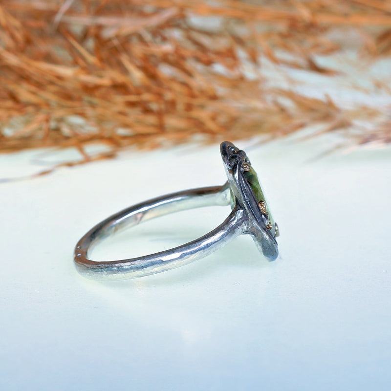 Ring with peridot with Ludwigite rutile