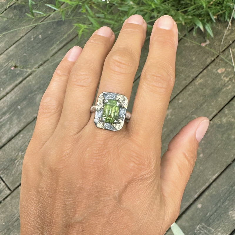 Ring with bright green peridot and gold flecks