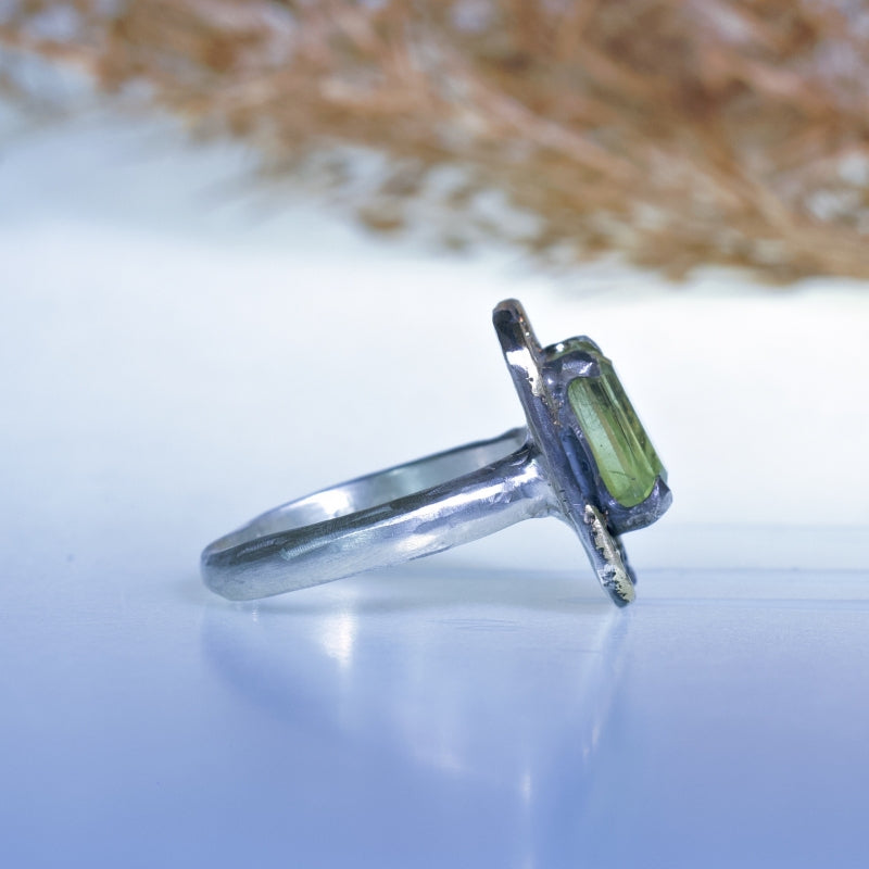 Ring with bright green peridot and gold flecks