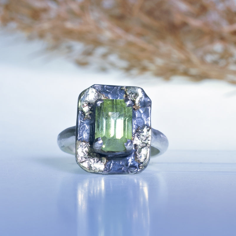 Ring with bright green peridot and gold flecks